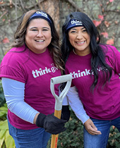 Two Think Bank employees posing for a photo while working outdoors.