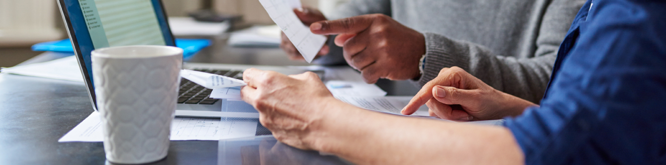 Couple looking at documents with computer