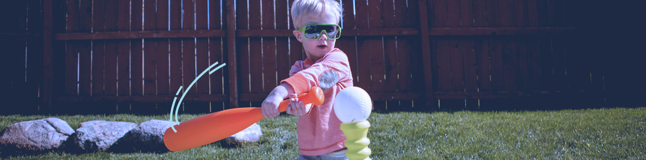 A child playing tee ball In the backyard of a home