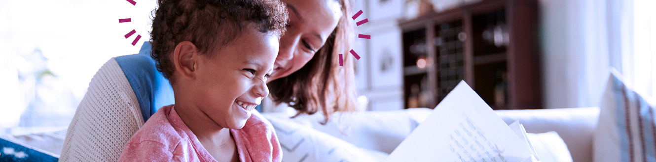 A child sitting on a women's lap looking at documents.