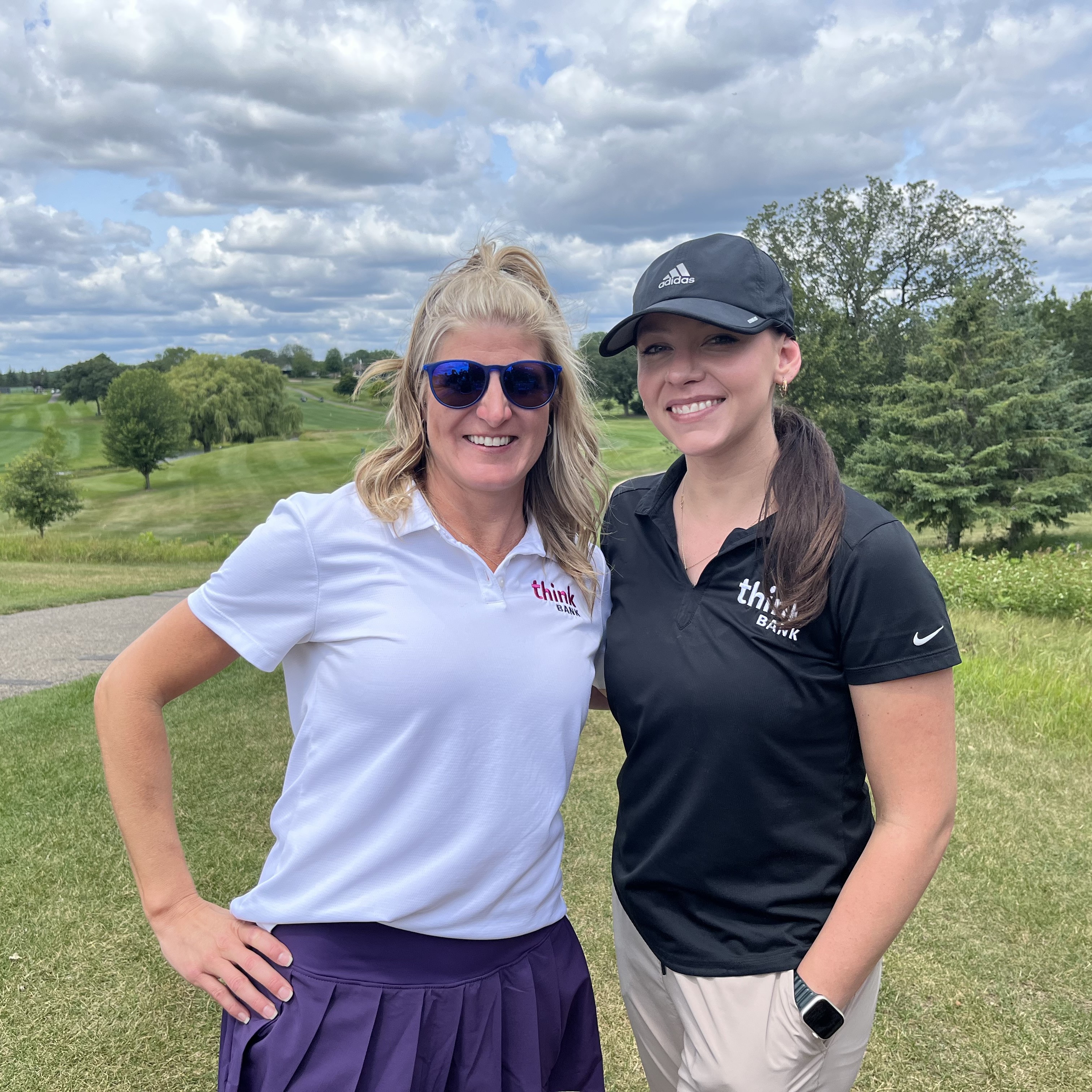 Two Think Bank employees on the golf course for a community event.