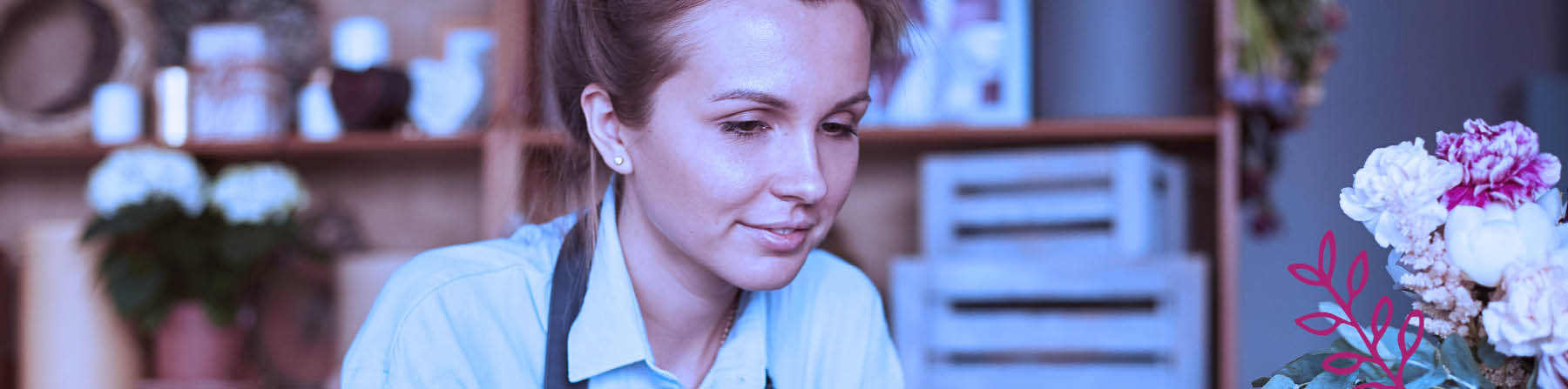 A women working at the desk of a floral shop.