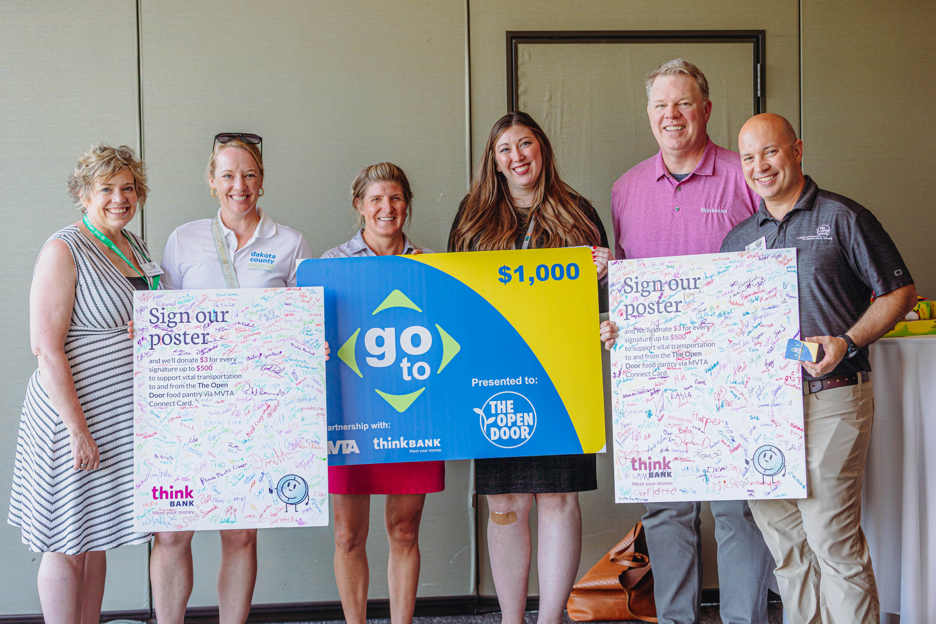 a group posing with signed posters