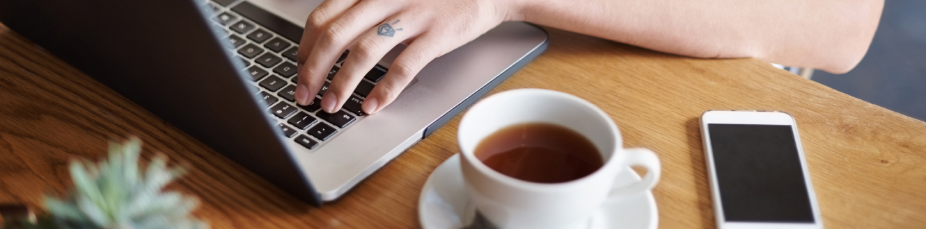 A person typing on their laptop computer